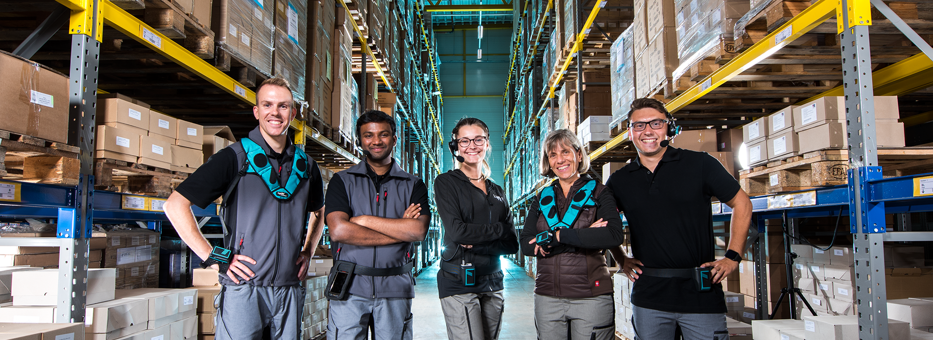 La imagen muestra a cinco trabajadores del almacén que trabajan con los dispositivos de voz.